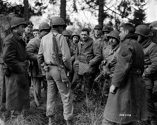 Soldiers from the 28th Infantry Division band and Quartermaster Company shown in Bastogne after slowing the German advance at Wiltz in December 1944.